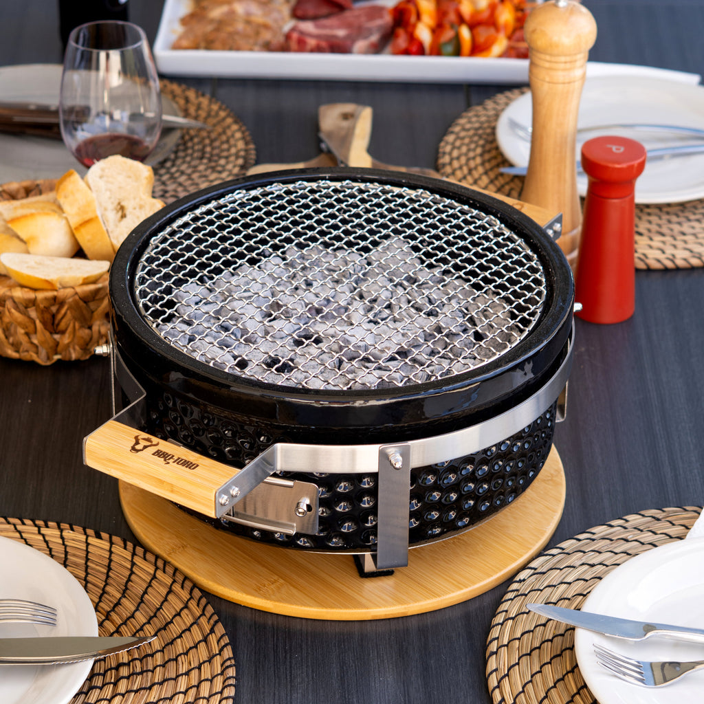 Barbecue de table au charbon de bois, en céramique, avec socle en bois.