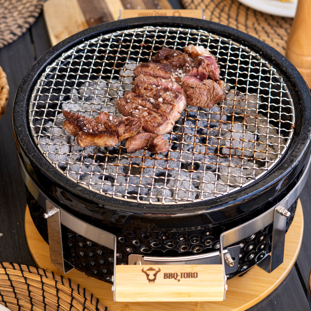 Barbecue de table au charbon de bois, en céramique, avec socle en bois.