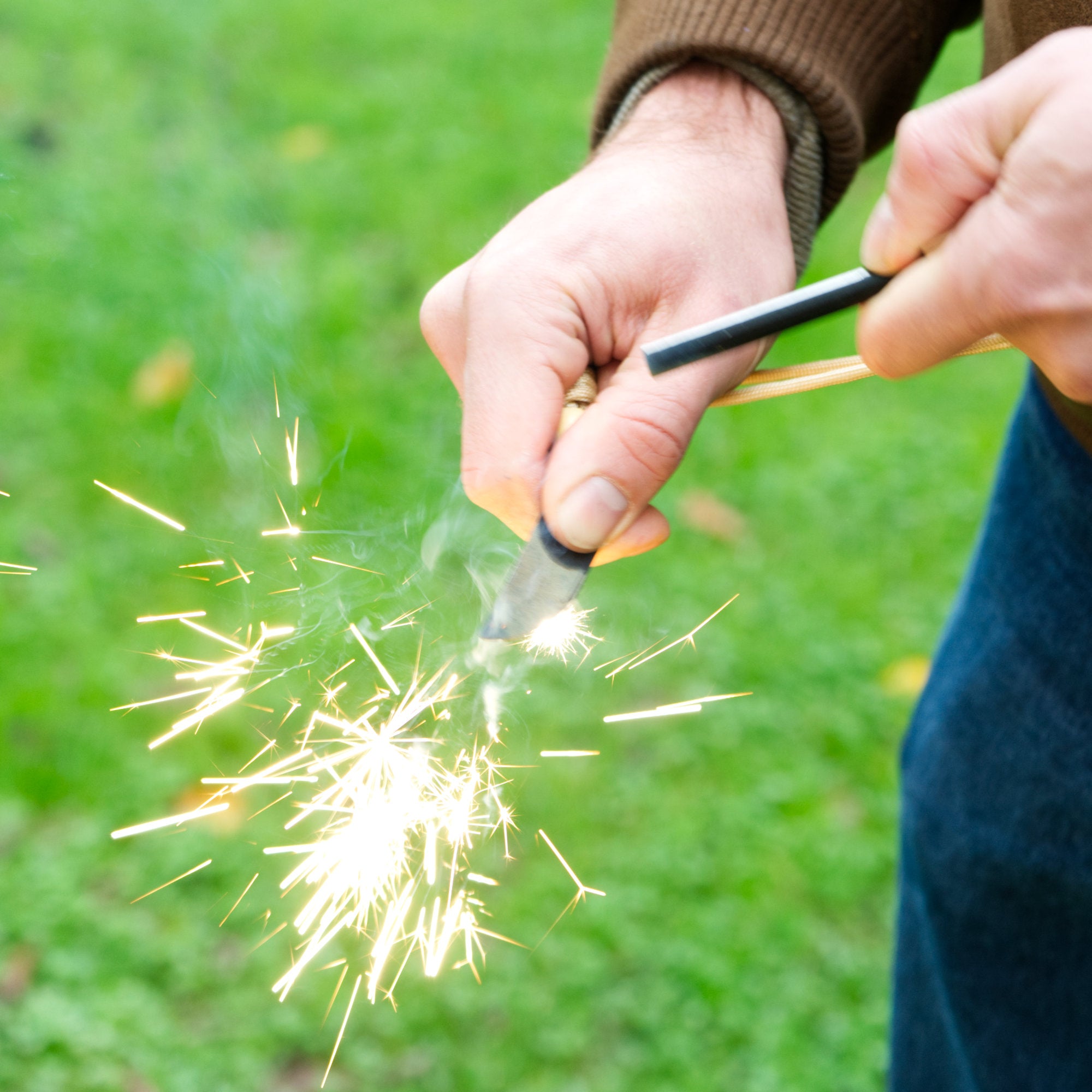 Ensemble allume-feu, comprenant un allume-feu, un grattoir en forme de lame et un allume-barbecue, le tout dans une boîte en acier inoxydable.