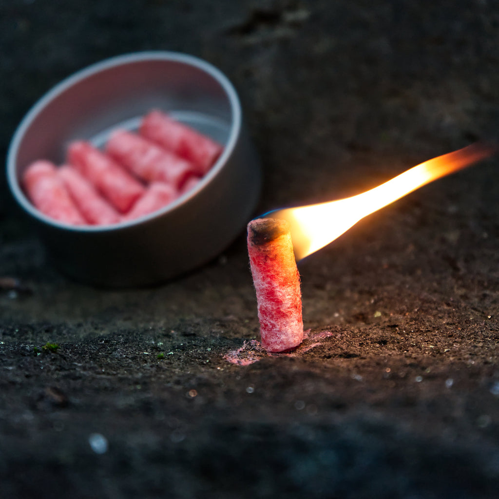 Kit de survie 6 pièces, comprenant une cocotte en fonte, une marmite à griller, une pierre à feu, un allume-feu et du charbon de bois.