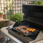 Plaque de cuisson réversible, 40 x 20,5 cm, en fonte pré-culottée, avec poignées et grille.