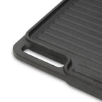 Plaque de cuisson réversible en fonte, pré-culottée, avec poignées et grille.
