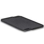 Plaque de cuisson réversible en fonte, pré-culottée, avec poignées et grille.