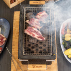 Barbecue de table au charbon de bois, en céramique, avec socle en bois.