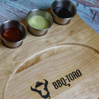 Plat de service ovale, 24 x 17,5 cm, comprenant des bols à trempette en acier inoxydable et une base en bois.