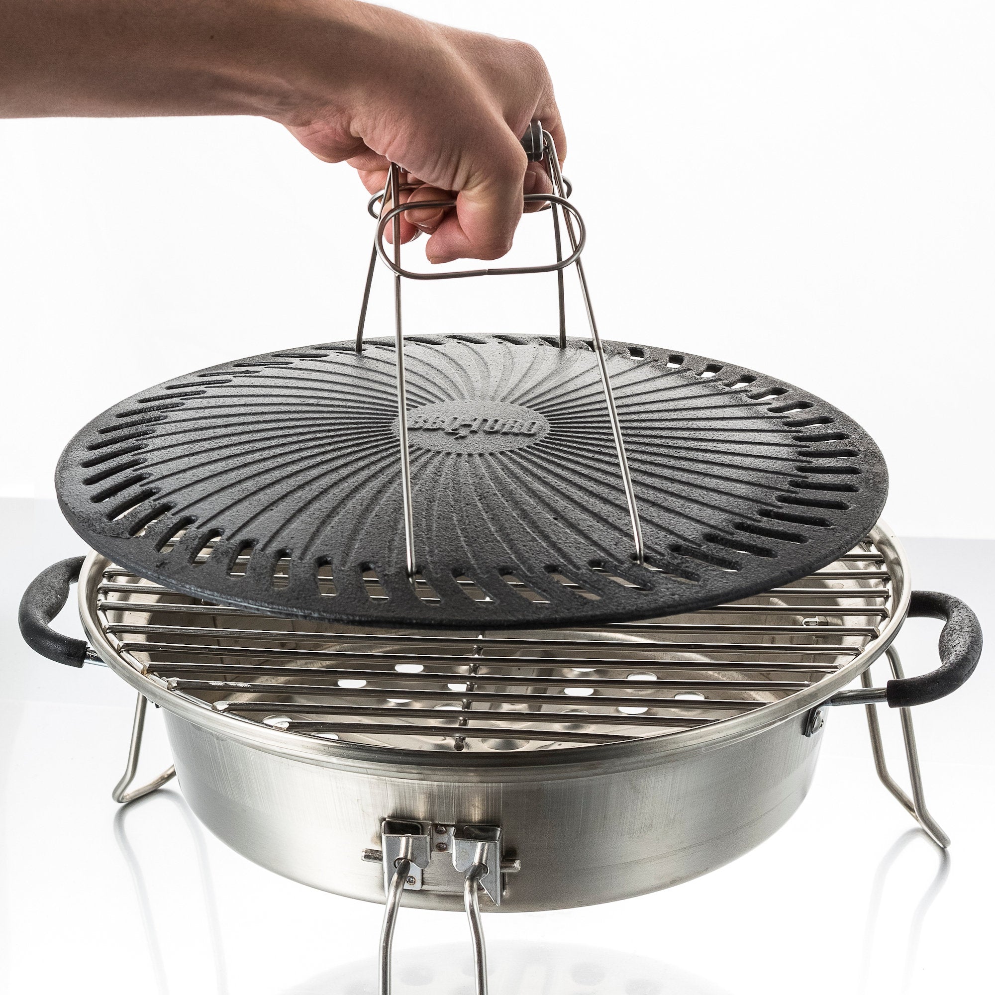 Ensemble de grilles pour poêle à fusée, comprenant une plaque de cuisson en fonte, une grille de cuisson, un bac de récupération des graisses et un lève-gril.