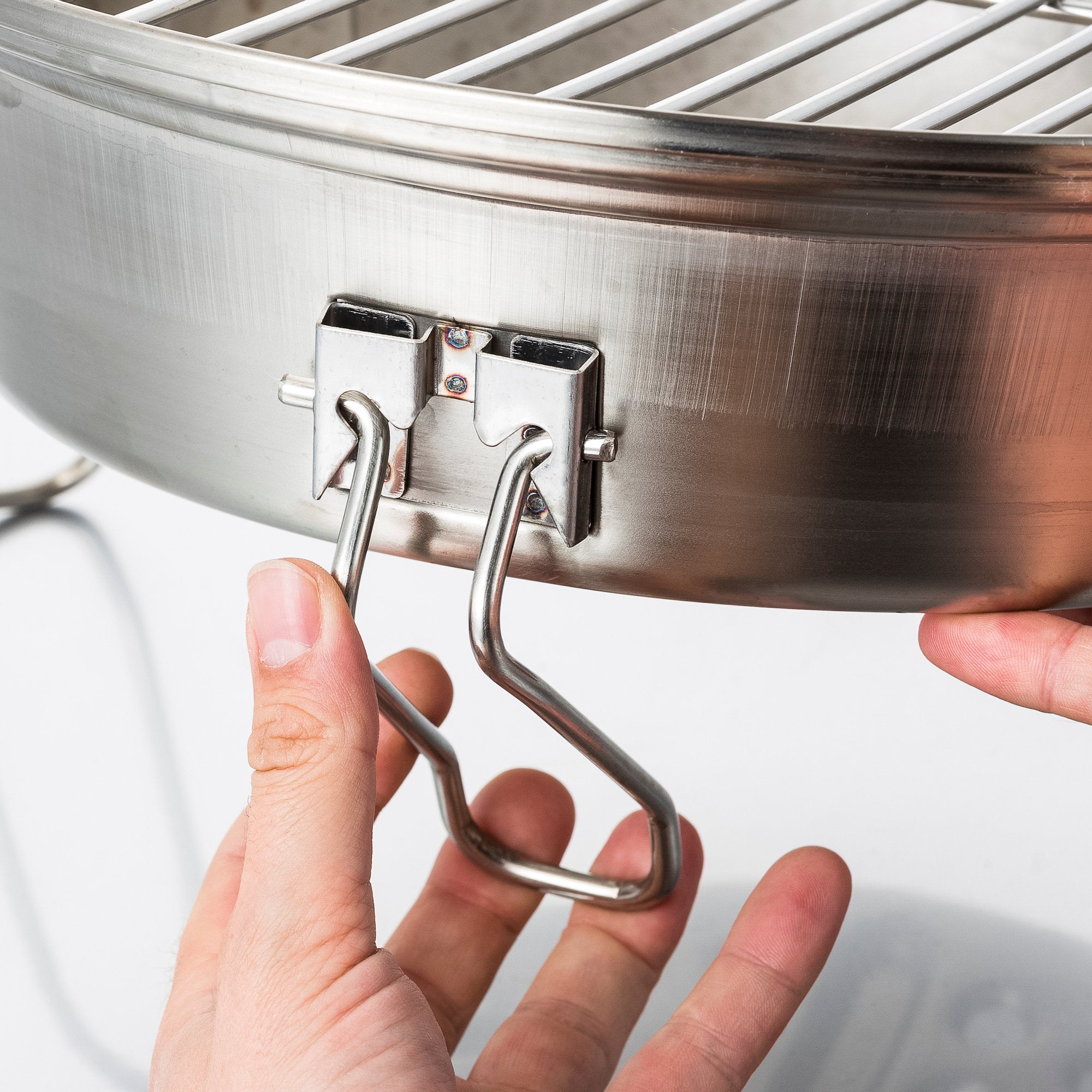 Ensemble de grilles pour poêle à fusée, comprenant une plaque de cuisson en fonte, une grille de cuisson, un bac de récupération des graisses et un lève-gril.