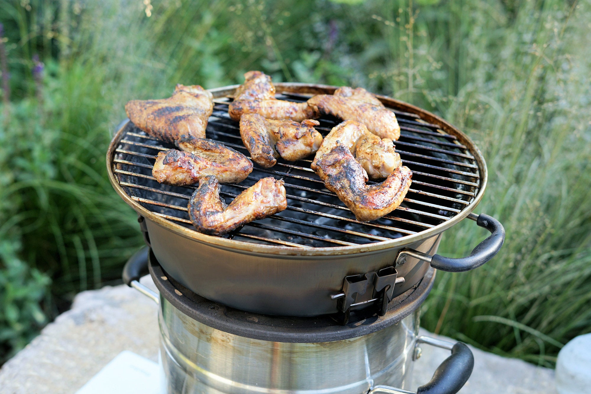 Ensemble de grilles pour poêle à fusée, comprenant une plaque de cuisson en fonte, une grille de cuisson, un bac de récupération des graisses et un lève-gril.